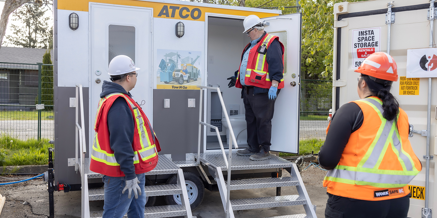 A group of people wearing high-vis vests inspecting a washroom
